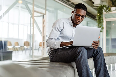 Man on a laptop using Odessa's asset finance portfolio management software.